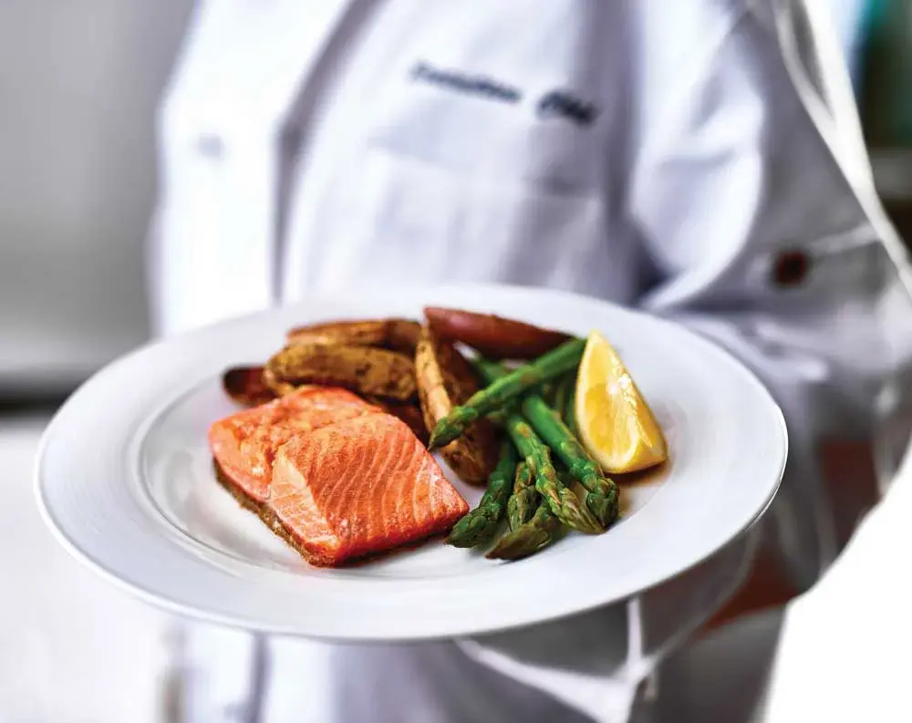 The Woods at Holly Tree Chef Created Meals, chef delivering a finished dish.