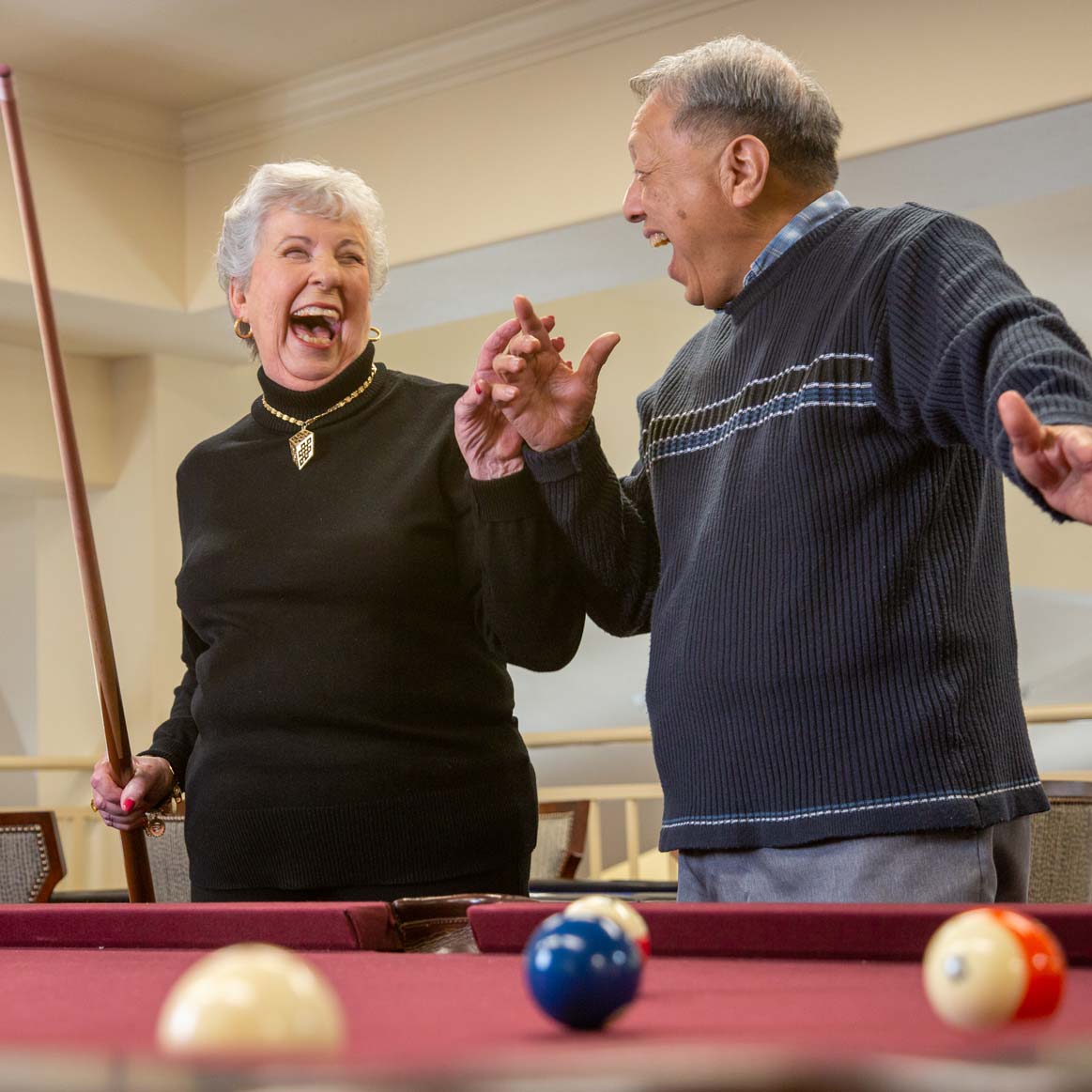 Residents playing billiards at The Woods at Holly Tree